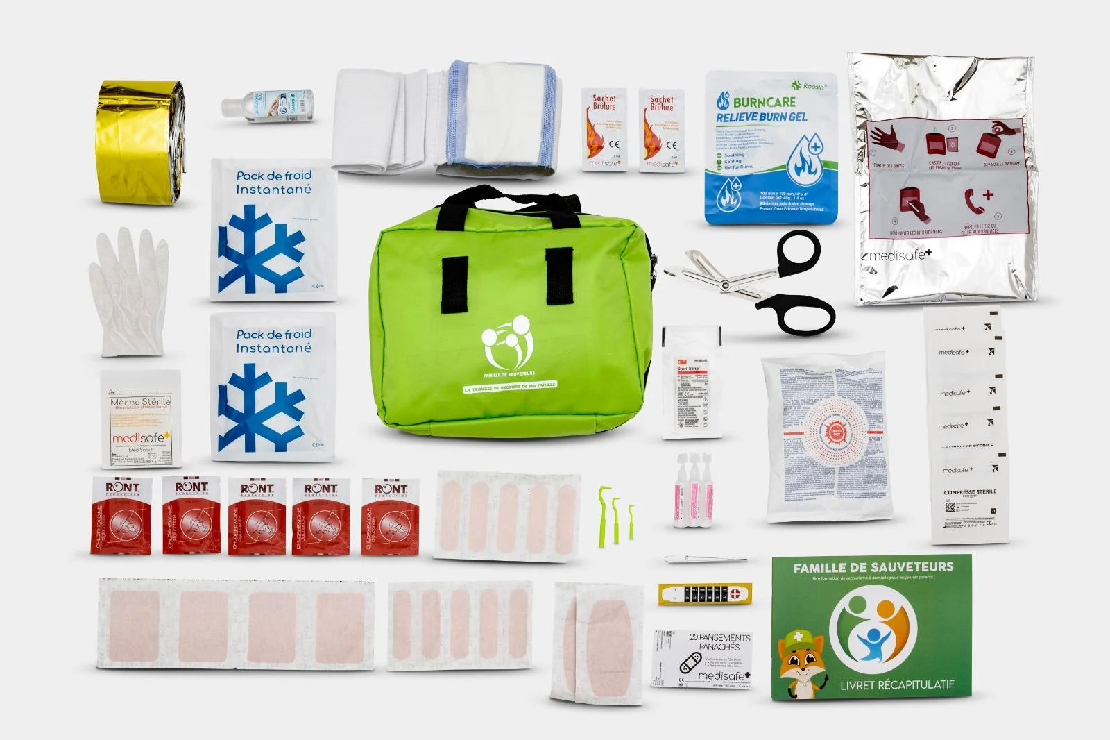 Le contenu complet de la trousse de secours Famille de Sauveteurs étalé : pansements, compresses, packs de froid, couverture de survie, ciseaux, livret récapitulatif